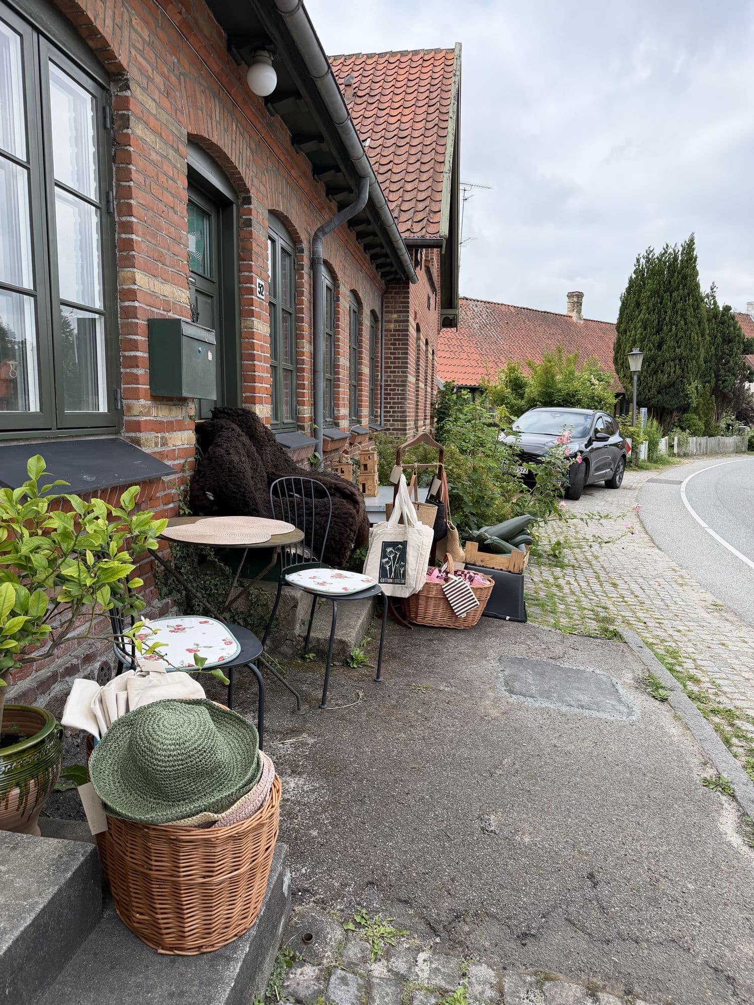 Outdoor seating with baskets and bags in front of the shop