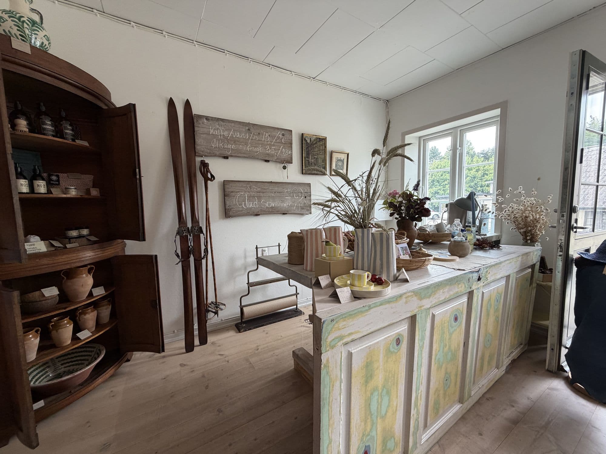 The shop counter with old skis, handwritten signs and a bouquet of wheat ears