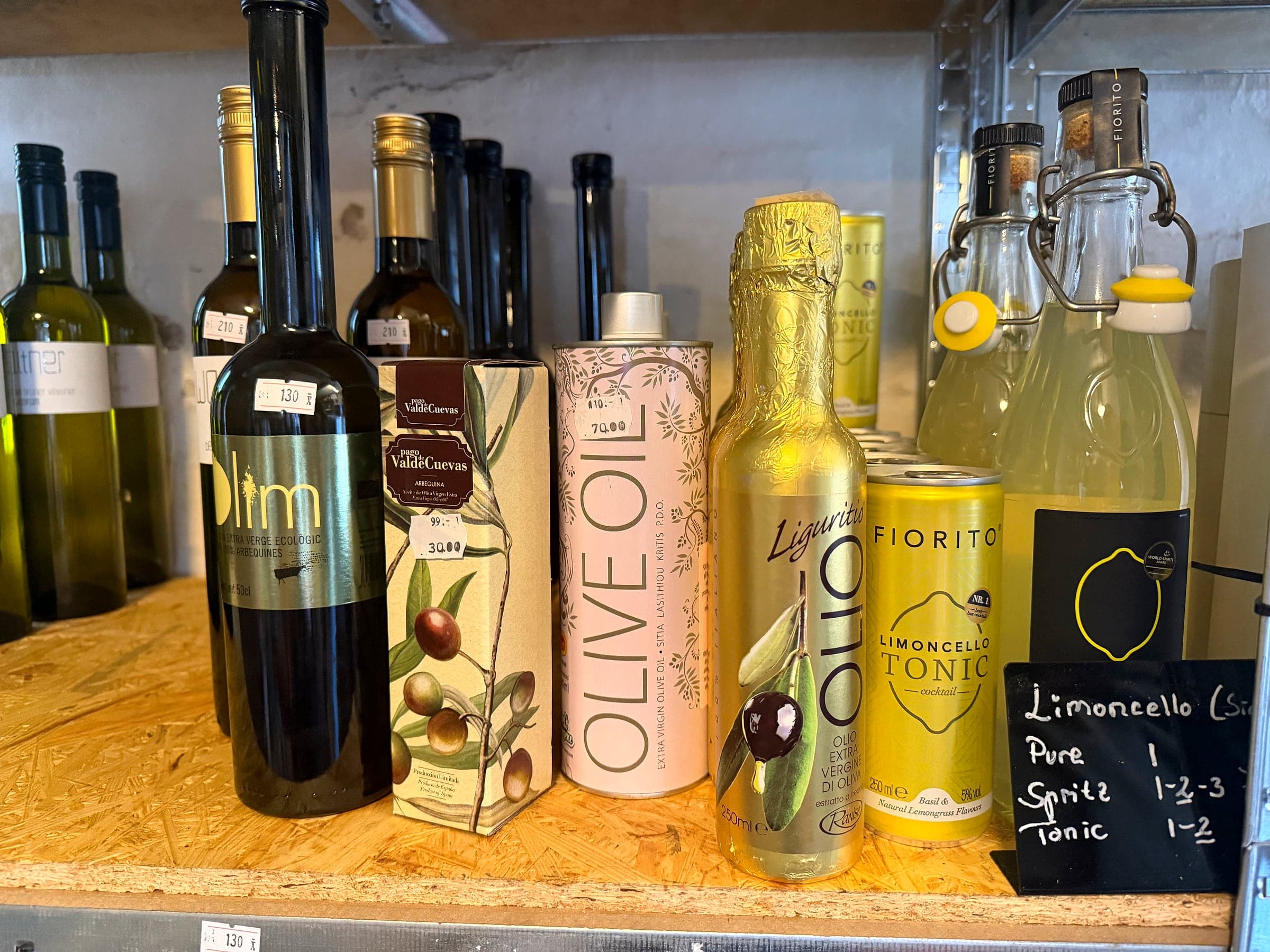 Olive oil, limoncello and tonic side by side on the shelf