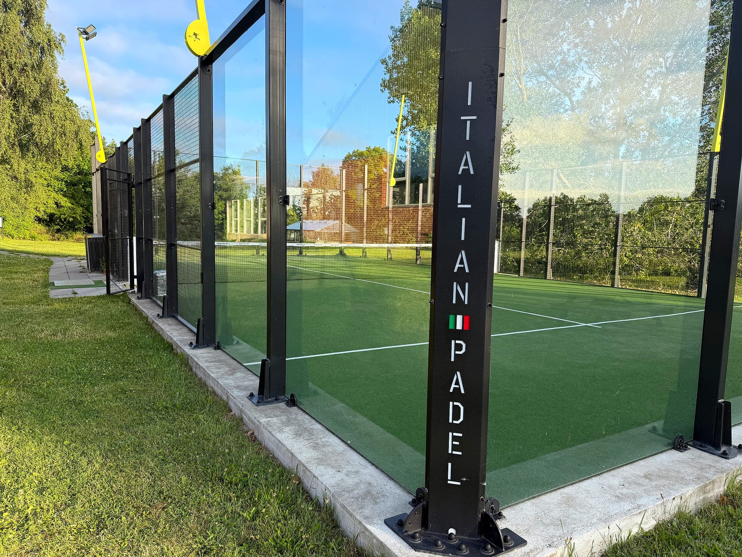 Nahaufnahme der Glaswand auf dem Padelplatz mit dem Schriftzug Italian Padel