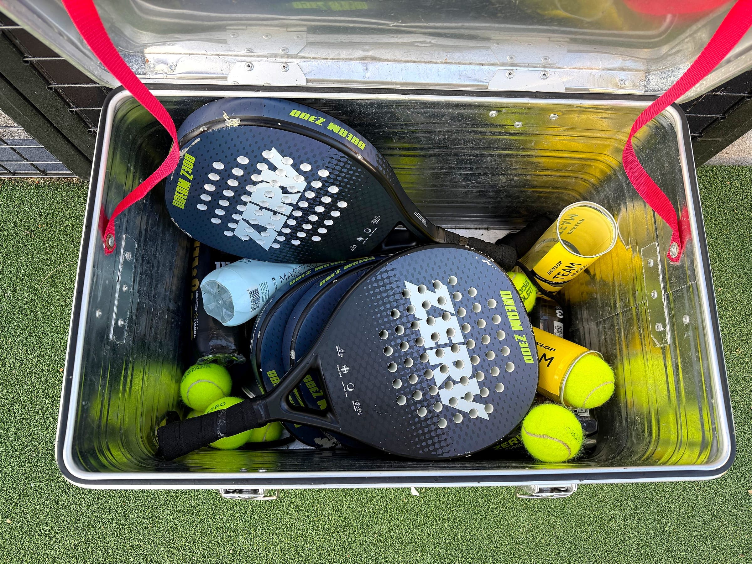Kiste mit Padelschlägern und Bällen, bereit zum Ausleihen am Platz
