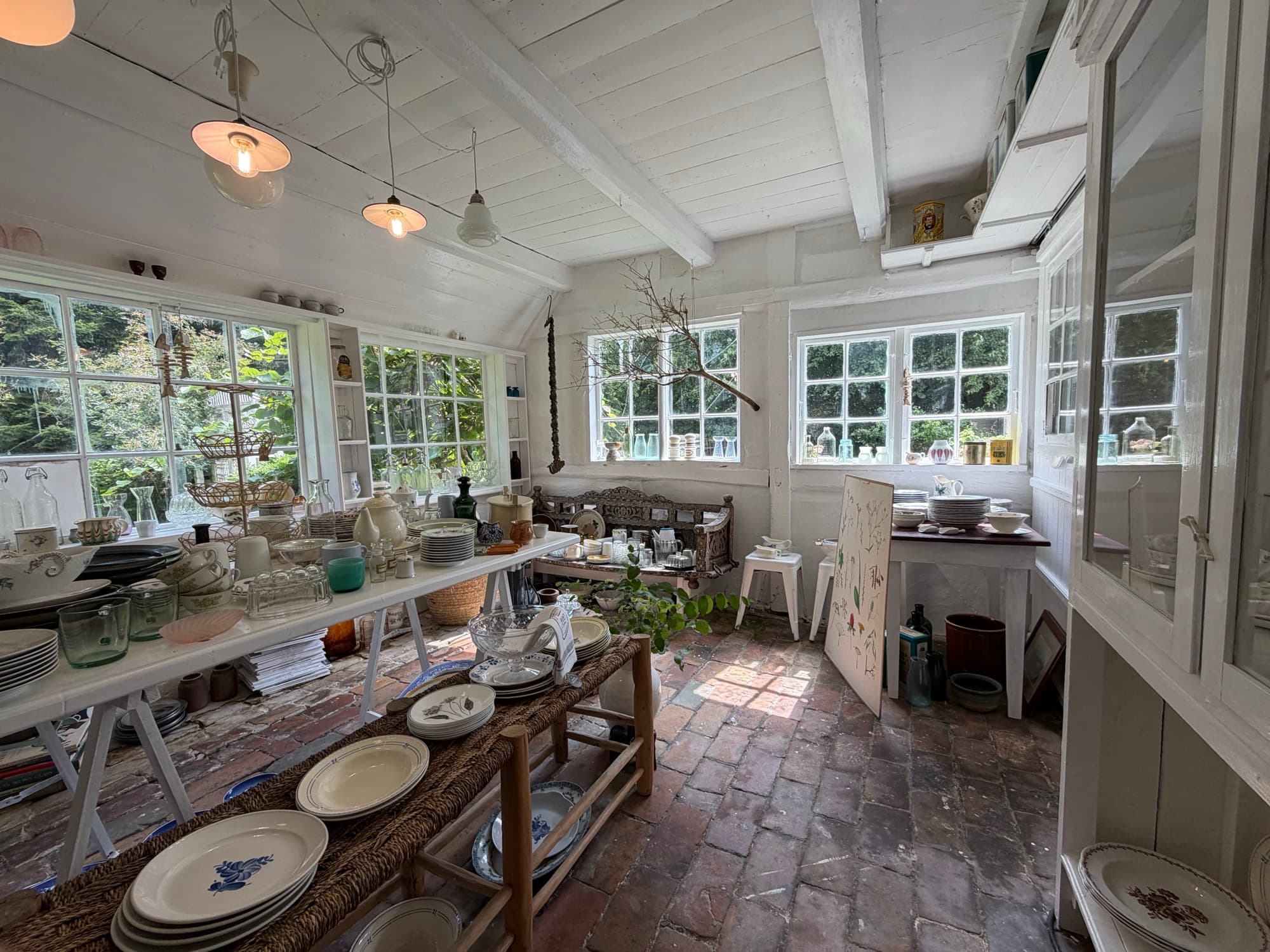The shop interior with old porcelain and glass on long tables