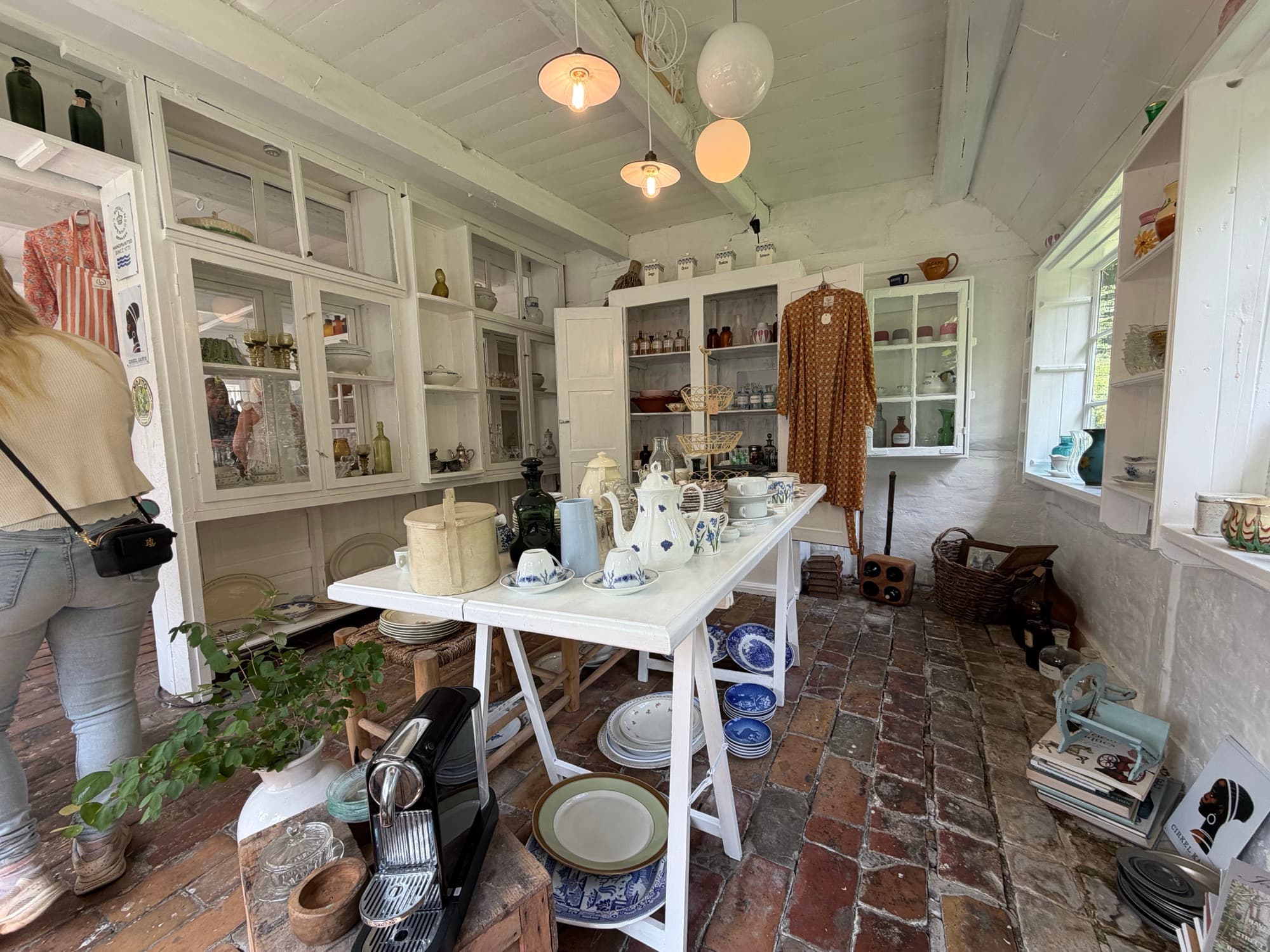 A guest browsing vintage clothing and decor in the shop