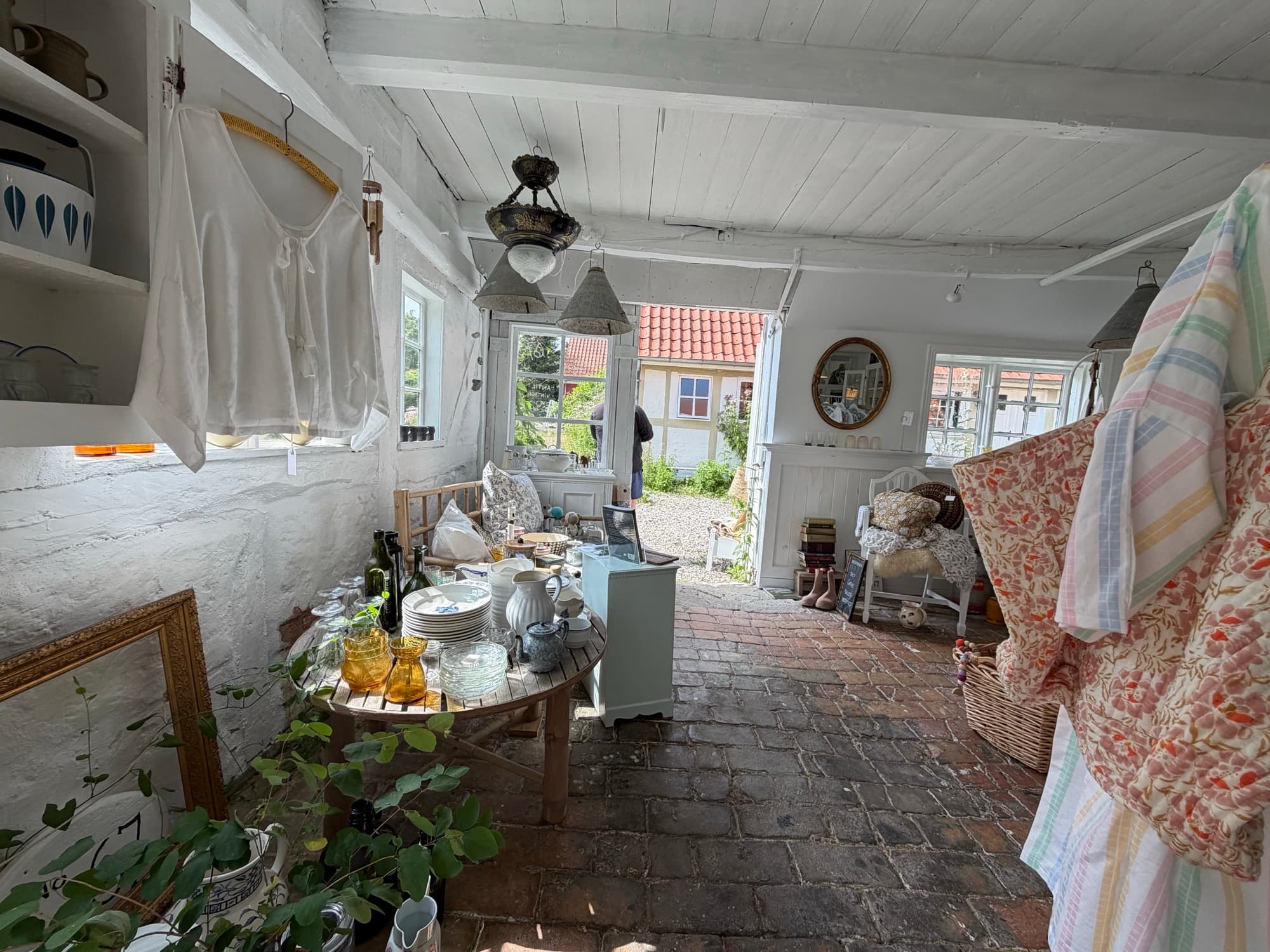 A room with a view to the garden and a selection of clothing and glass