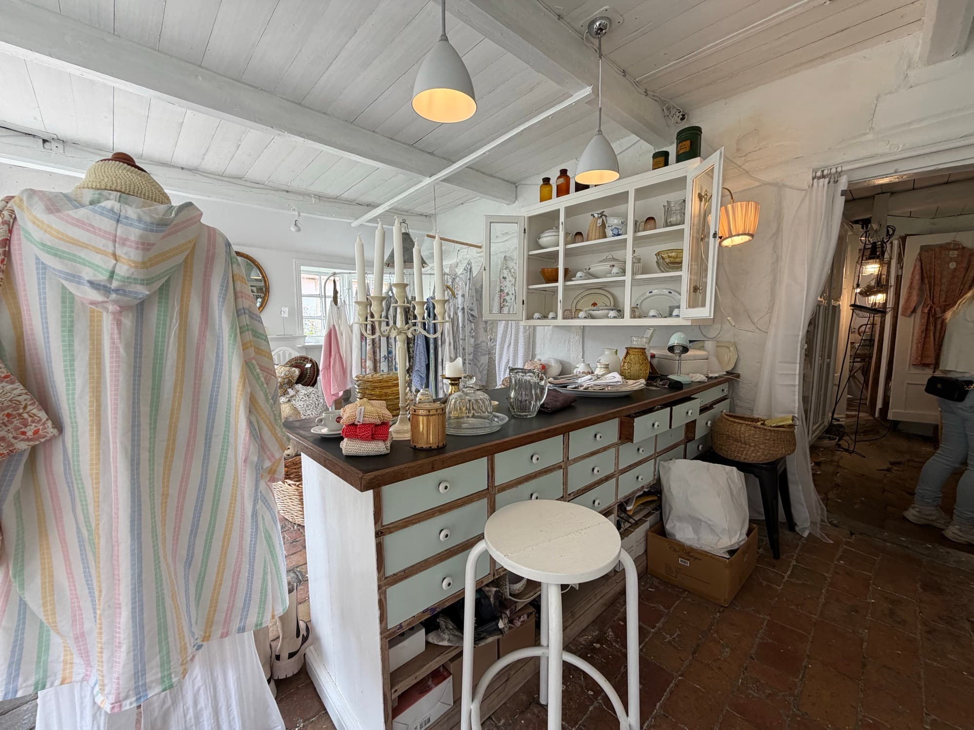 A striped vintage robe and candelabra in front of a glass cabinet