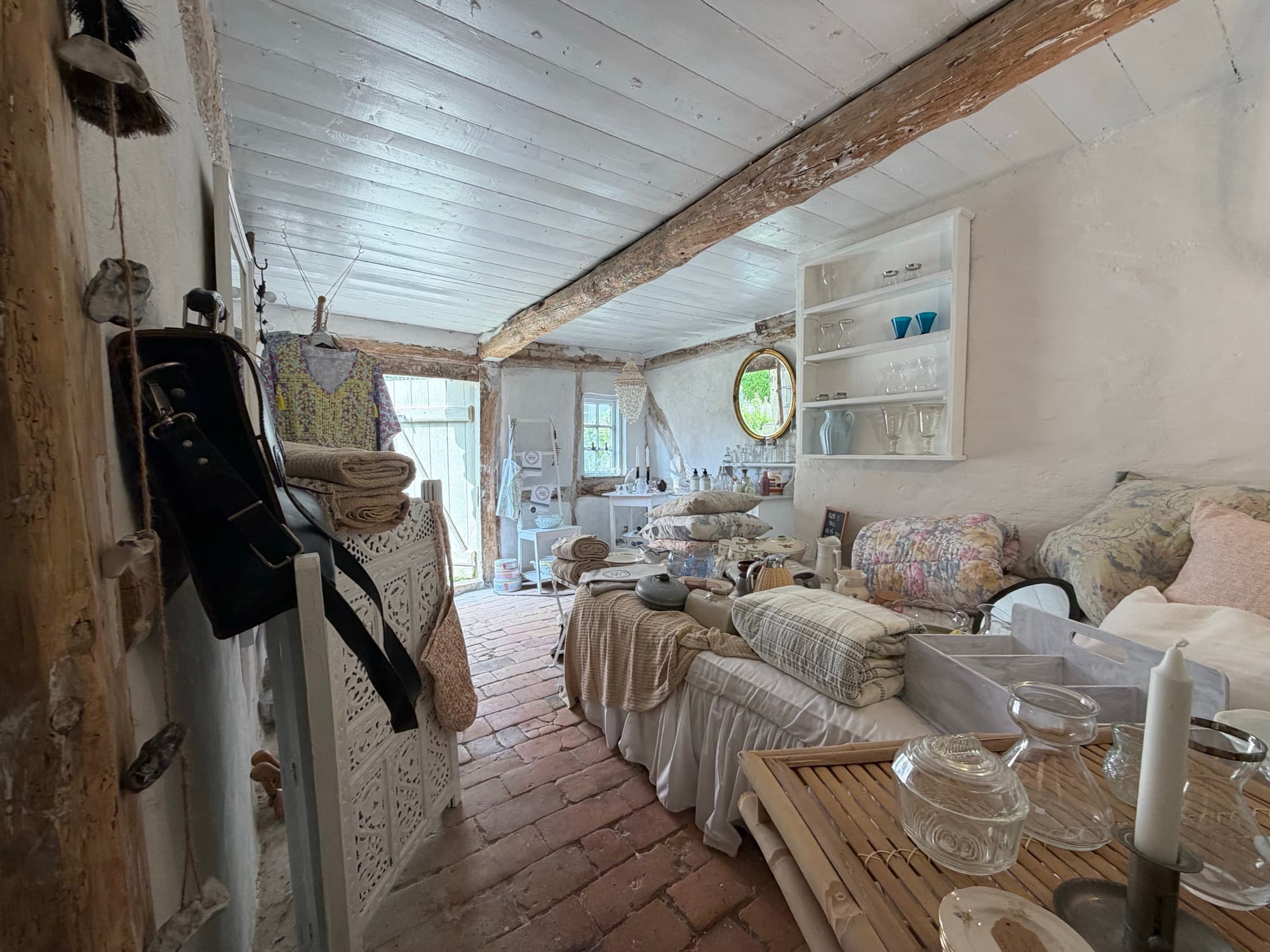 A cosy corner with a mirror, shelves and textiles