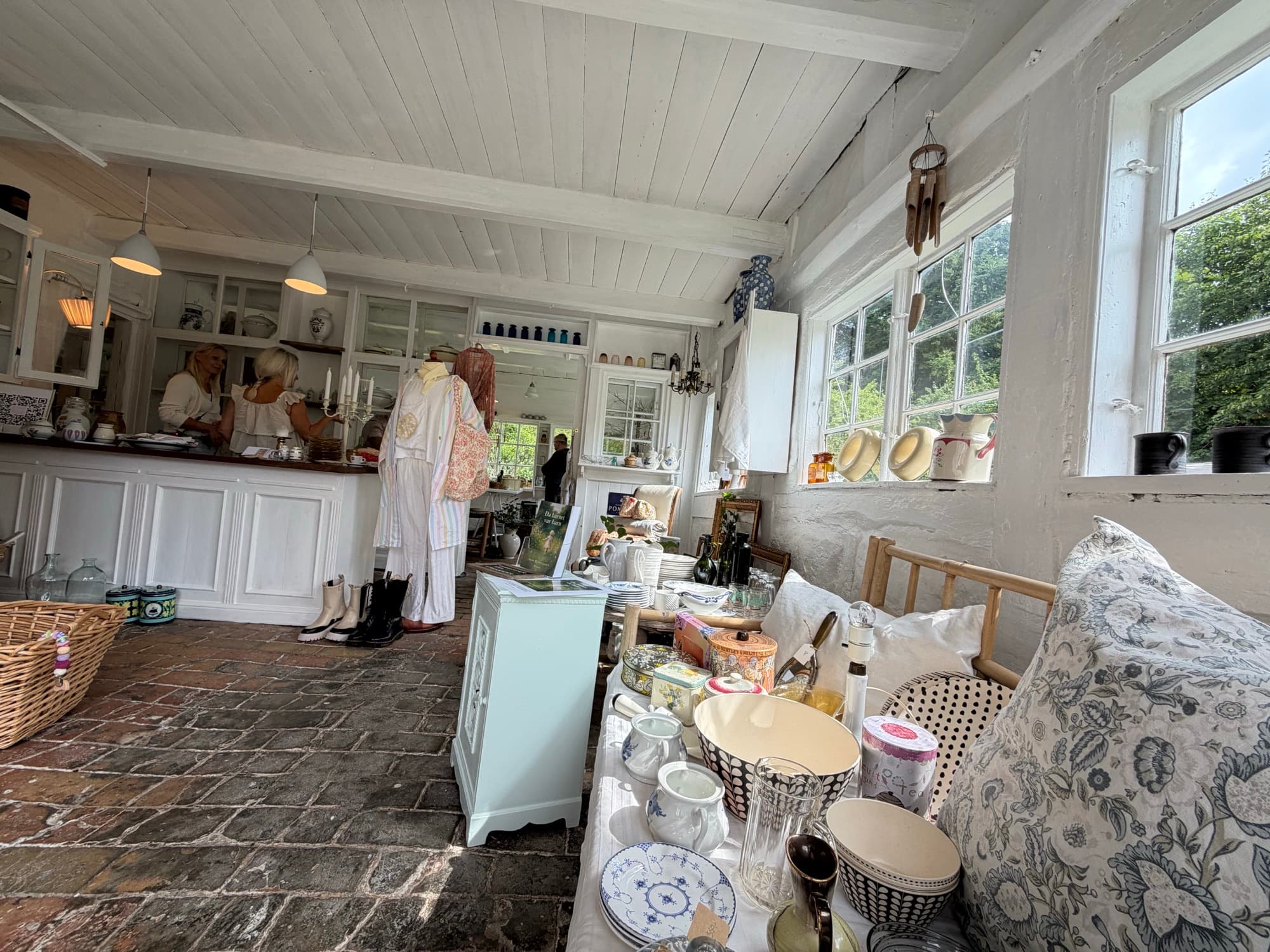 Two guests at the counter surrounded by vintage clothing