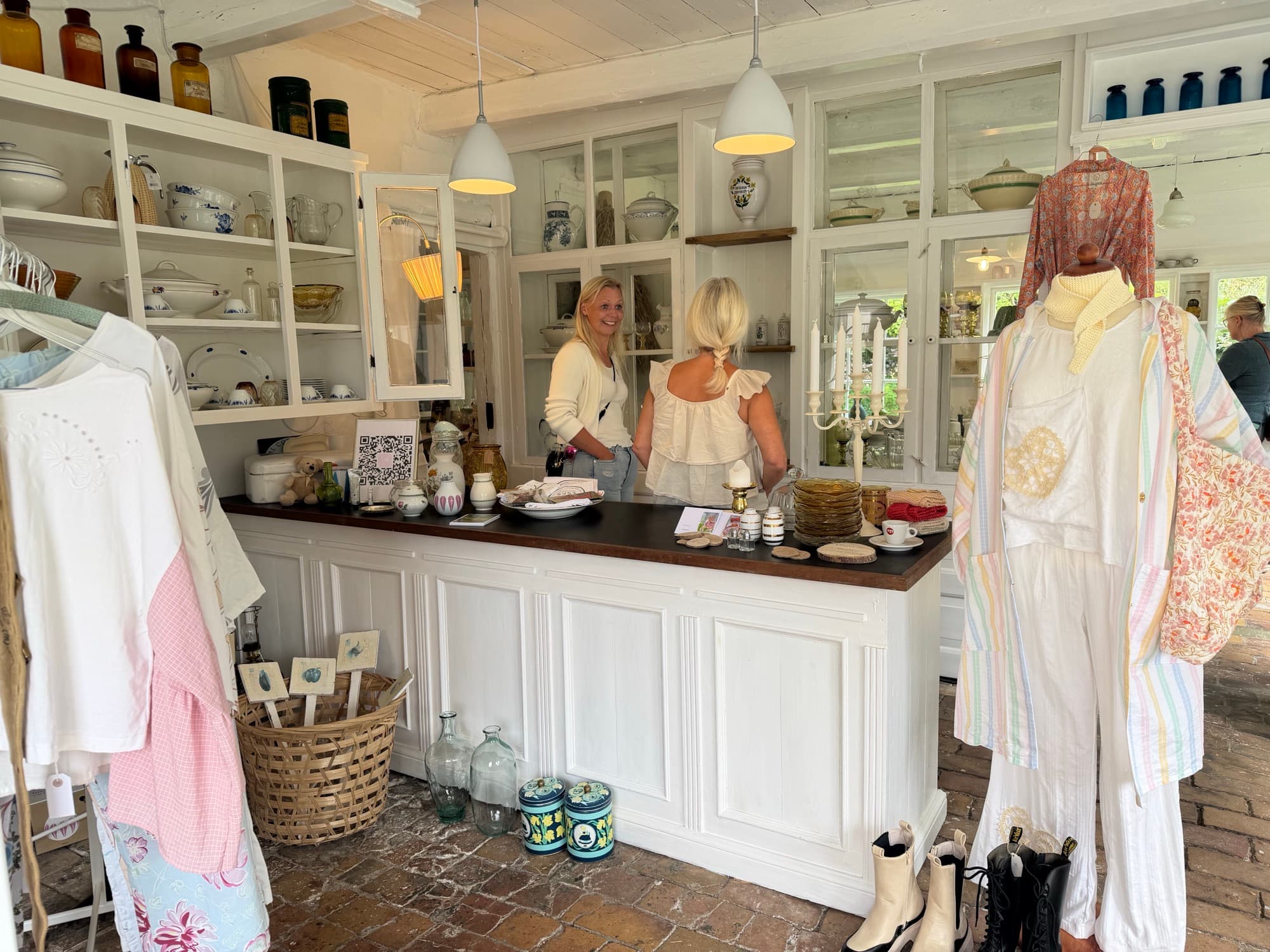 The counter with porcelain shelves and vintage clothing on a rack