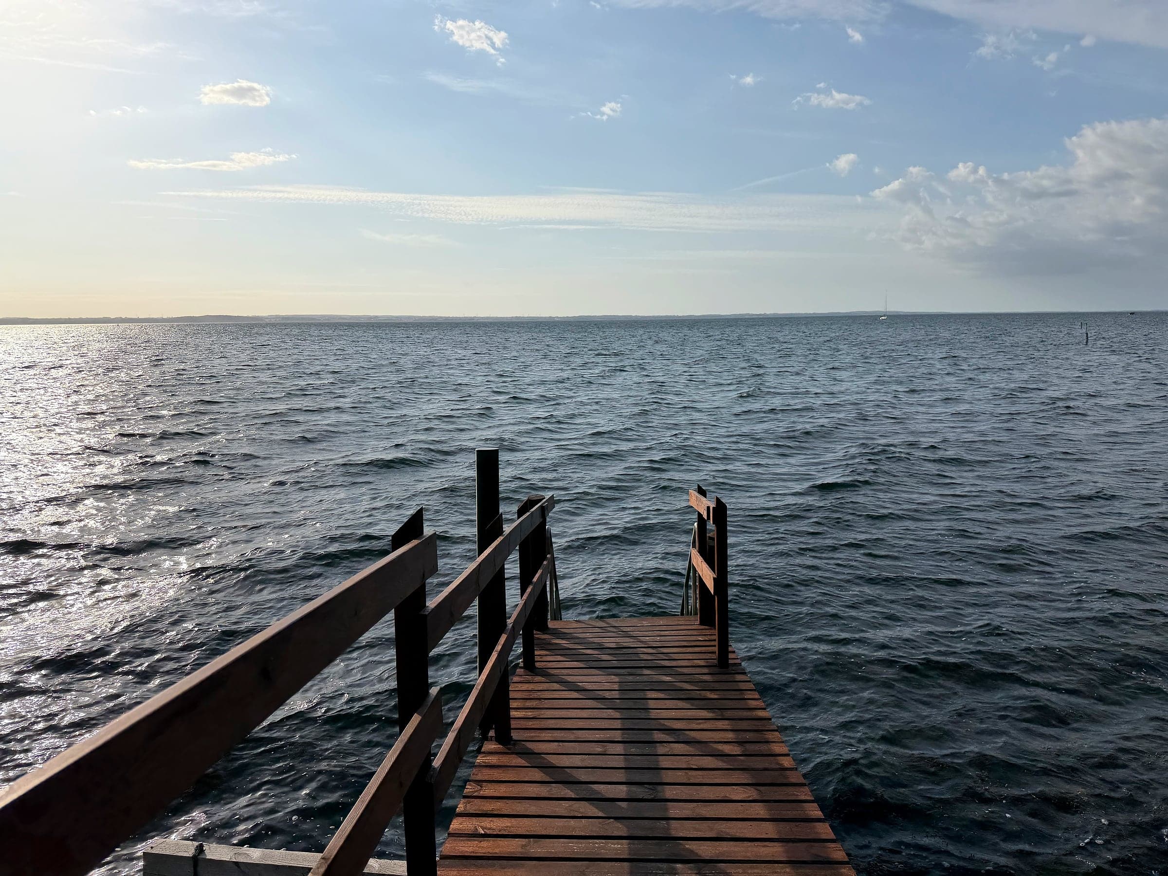 Die Holztreppe hinunter zum Wasser am Ende des Stegs bei der Sauna