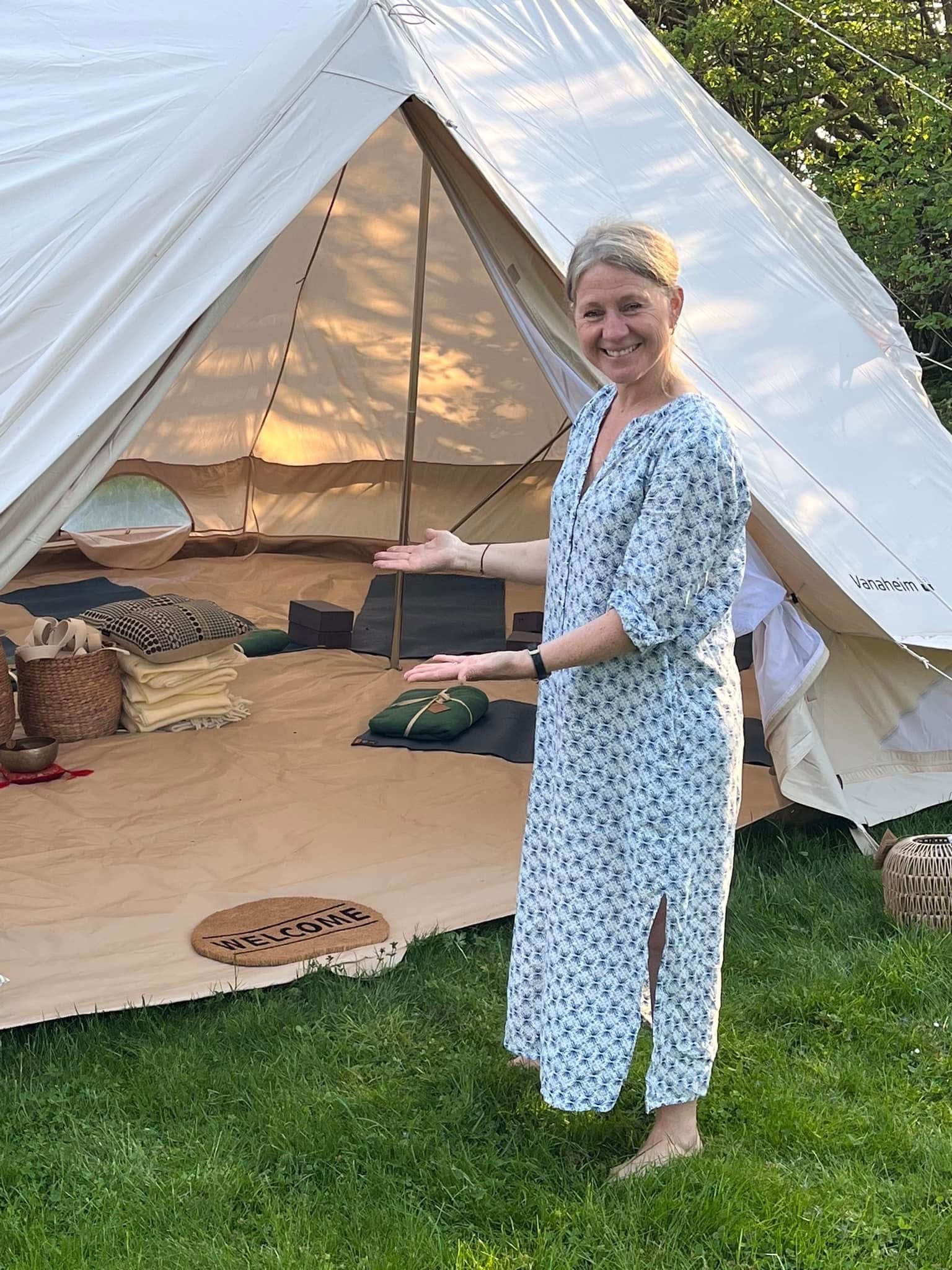 Yoga instructor welcoming guests at the entrance of the yoga tent